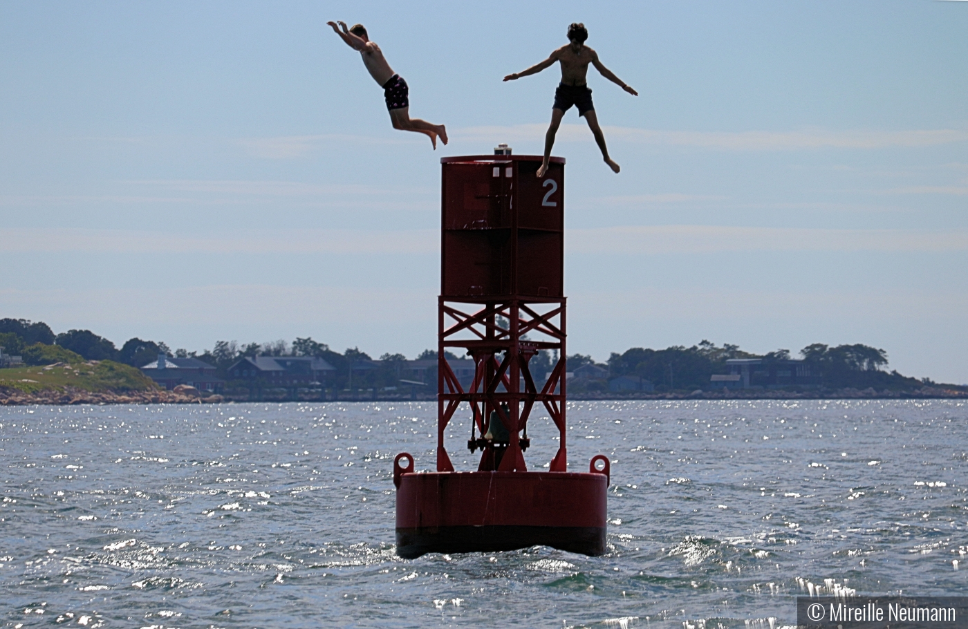 boys jumping off buoy by Mireille Neumann
