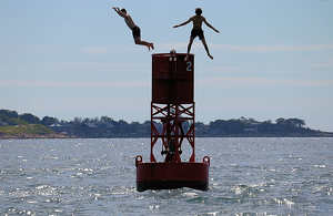 boys jumping off buoy - Photo by Mireille Neumann